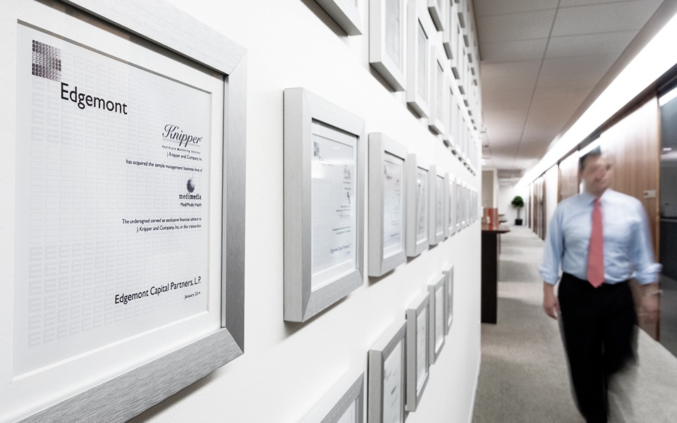 Man walking through hallway with picture frames